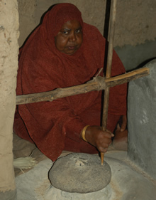 Women milling grain in the traditional Omani way in al Hamra